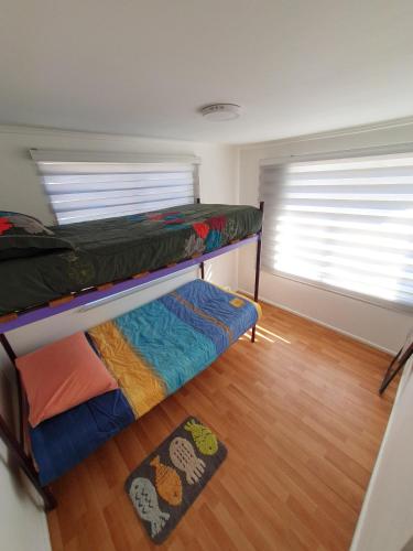 a room with two bunk beds and a wooden floor at alojate en la playa litera baño compartido 