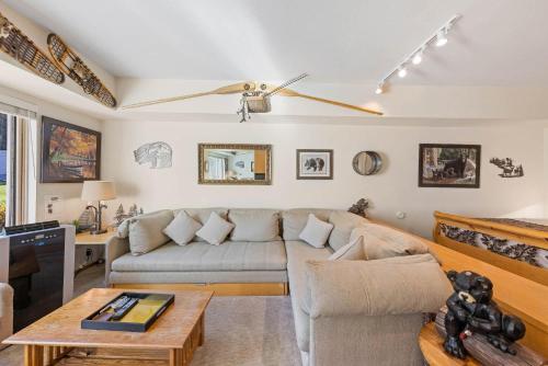 a living room with a couch and a tv at Palisades Tahoe Lodge Rentals Studio #214 in Olympic Valley