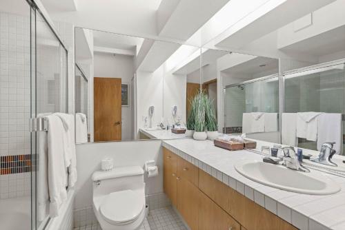 een badkamer met een toilet, een wastafel en een spiegel bij Studio #223 in Olympic Valley