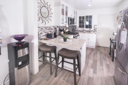 a kitchen with a table and stools and a refrigerator at Blanquitas Home in Long Beach