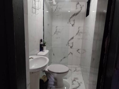 uma casa de banho branca com um WC e um lavatório em Loft Eco City 02-Espaçoso e Confortável c/ Garagem em Curitiba