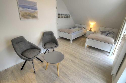 een kamer met 2 bedden, 2 stoelen en een tafel bij Ferienhaus Segelblick Lee - b49659 in Holnishof