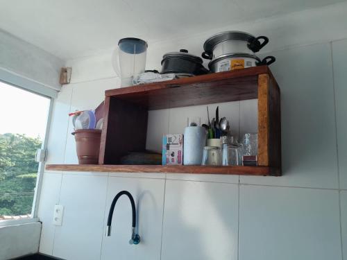 een keuken met een plank met potten en pannen erop bij Casa da India in Cayru