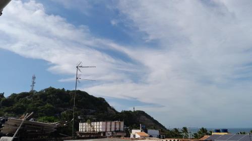 een bewolkte lucht met een windmolen voor een heuvel bij Casa da India in Cayru