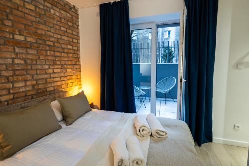 1 dormitorio con pared de ladrillo y 1 cama con toallas en Apartament z Tarasem, en Toruń