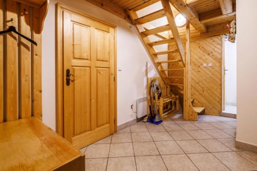 an attic room with a wooden door and a staircase at Chaloupka u Káji in Vítkovice