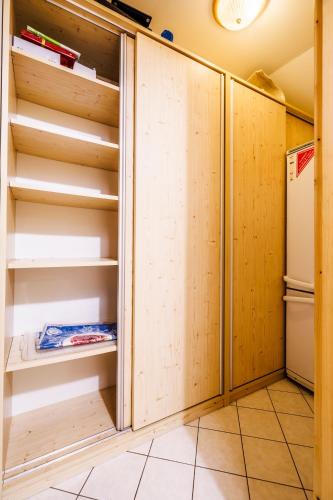 a kitchen with wooden cabinets and a refrigerator at Chaloupka u Káji in Vítkovice