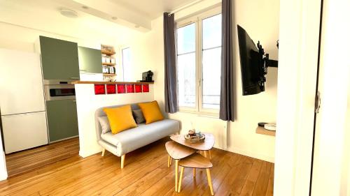 un salon avec un canapé et une table dans l'établissement L'oasis d'Enghien-les-bains, à Enghien-les-Bains