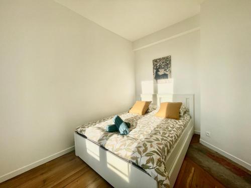 - une chambre blanche avec un lit et des oreillers dans l'établissement L'oasis d'Enghien-les-bains, à Enghien-les-Bains