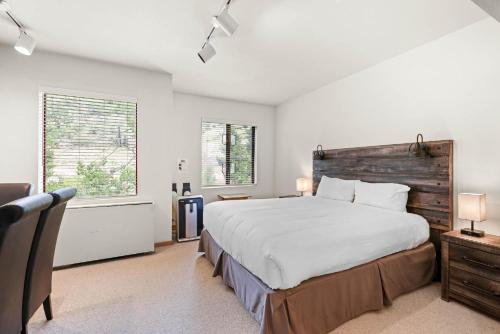 a bedroom with a large bed and two windows at Studio #249 in Olympic Valley