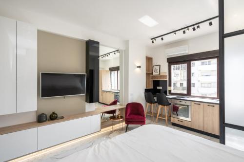 a bedroom with a bed and a tv on a wall at Victoriei112 - UrbanNest Bucharest in Bucharest