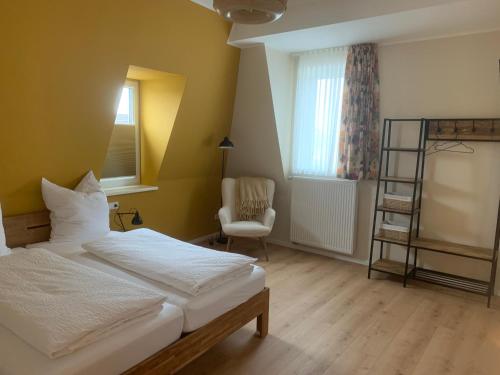 a bedroom with a bed and a ladder and a chair at Gästehaus Reichmann in Beverungen