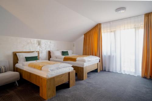a bedroom with two beds and a window at Casa Pe Vale in Râşnov