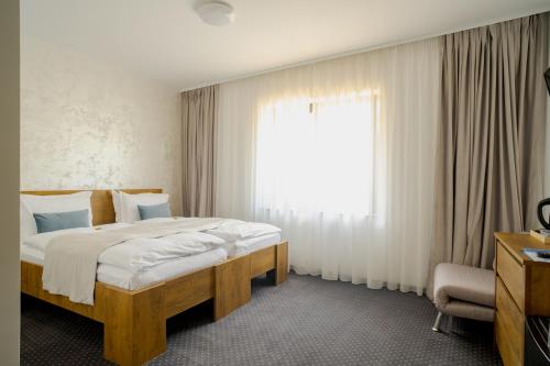 a bedroom with a bed and a large window at Casa Pe Vale in Râşnov