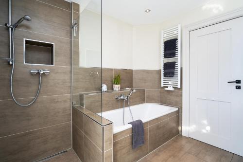 a bathroom with a tub and a shower at Sölring Lek Westerland in Westerland (Sylt)
