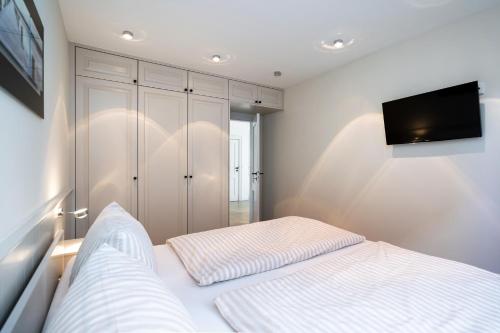 a bedroom with a bed and a flat screen tv at Sölring Lek Westerland in Westerland (Sylt)