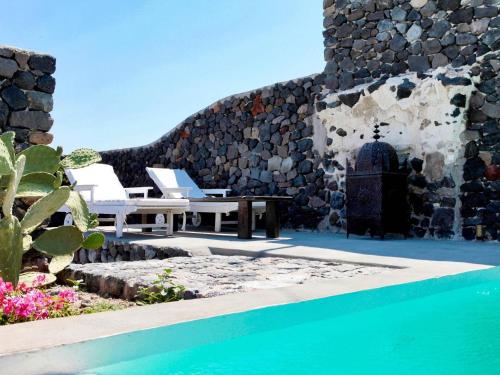メガロホリにあるVilla in Megalochori with Private Poolのビルの隣にテーブルと椅子付きのプール