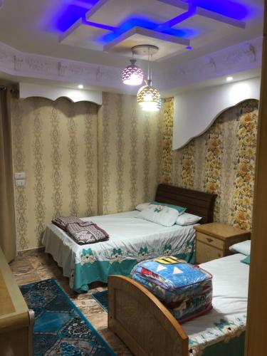 um quarto com 2 camas e um tecto azul em شقه بحر مباشر العصافرة em Alexandria