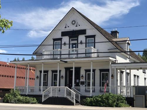 an old white house with a porch and balcony at Tahoe Star Hotel in Truckee