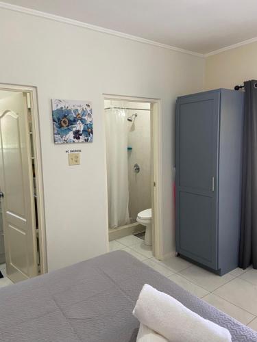 a bedroom with a blue cabinet and a bathroom at 1 Bed Cottage in Gated Community in Banks