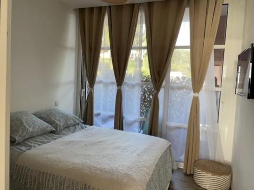 a bedroom with a bed and a large window at CAP ESTEREL, T2 VUE MER 4 couchages adapté PMR in Saint-Raphaël