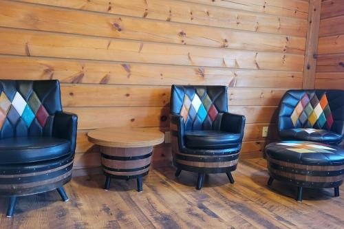 due sedie e un tavolo in una stanza con pareti in legno di The Grizzly Den Cabin Warrens WI a Warrens