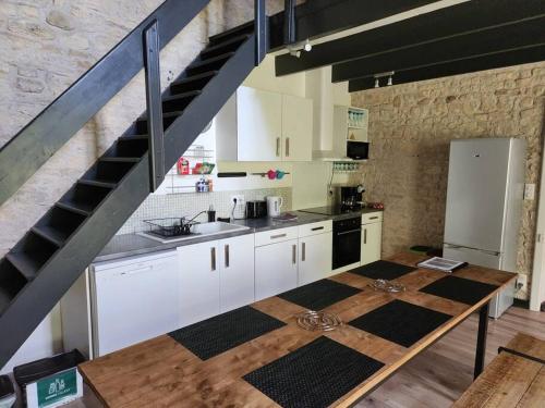 Andilly-les-Marais的住宿－Maison en pierre à 15 min de LA ROCHELLE avec SPA，一间厨房,配有白色橱柜和楼梯