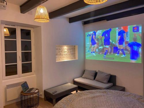 ein Wohnzimmer mit einer großen Leinwand an der Wand in der Unterkunft Maison en pierre à 15 min de LA ROCHELLE avec SPA in Andilly-les-Marais