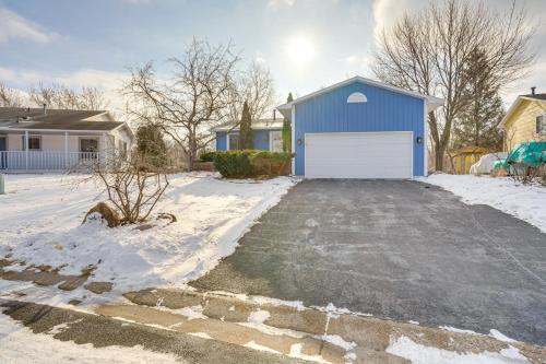 a blue house with a white garage in the snow at Charming Savage Home with Yard 18 Mi to Minneapolis in Savage