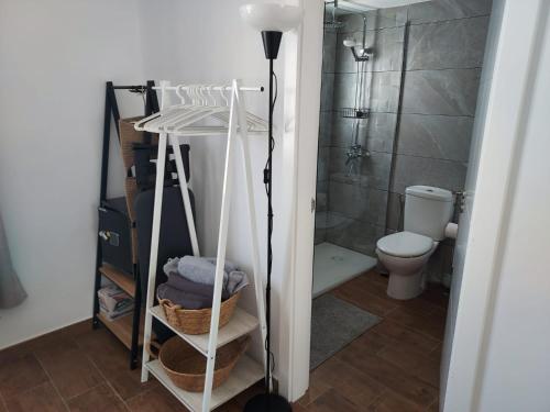 a bathroom with a shower and a toilet and a floor at Hestia Studio Apartment in Puerto del Carmen