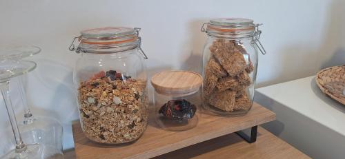 three glass jars filled with nuts on a wooden shelf at Reeves Retreat-Handy in Tasman in Nelson