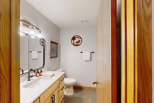 a white bathroom with a sink and a toilet at Snow Flower 101 in Steamboat Springs