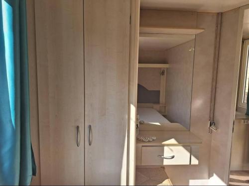 un armario en una habitación con algunos estantes en Comfortable campsite-chalet G14 Tuscany near sea, en Viareggio