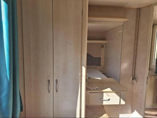 Comfortable campsite-chalet G16 Tuscany near sea في فياريجيو: خزانة في غرفة مع بعض الرفوف
