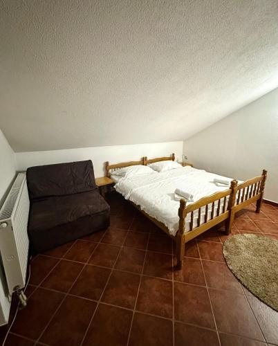 1 dormitorio con 1 cama y 1 sofá en Apartmani Ivan en Kupres