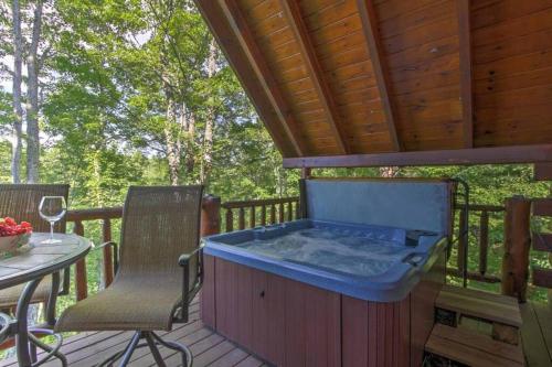 a hot tub on a deck with a table and chairs at Majestic View Hideaway in Sevierville
