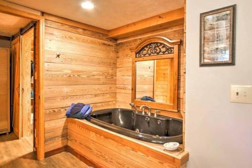 a bathroom with a tub in a wooden wall at Majestic View Hideaway in Sevierville