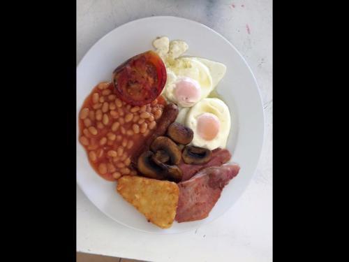 un piatto bianco di cibo con fagioli, fagioli, mais e carne di Newcastle Studios a Mália