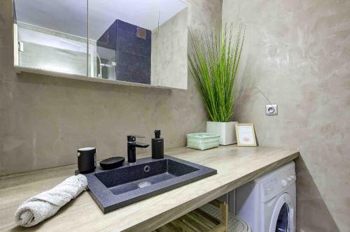 a bathroom with a sink and a washing machine at Flat design with SEA view promenade des anglais in Nice