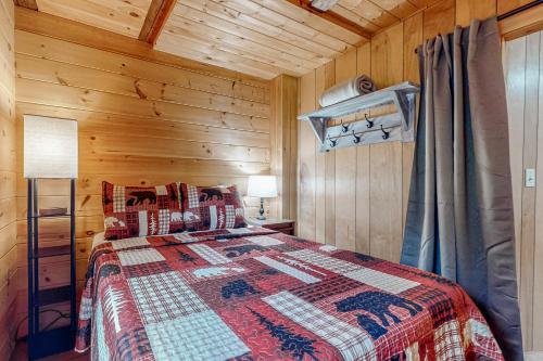 a bedroom with a bed with a quilt on it at Wassookeag Getaway in Dexter