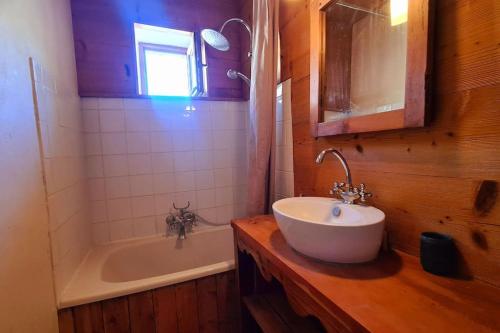 a bathroom with a sink and a bath tub at Appartement de charme, vue sur les montagnes. in Aiguilles