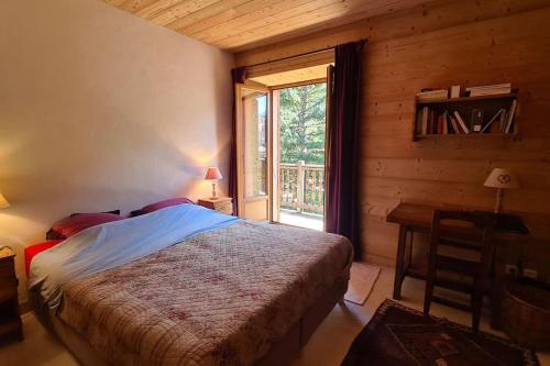 a bedroom with a bed in a room with a window at Appartement de charme, vue sur les montagnes. in Aiguilles