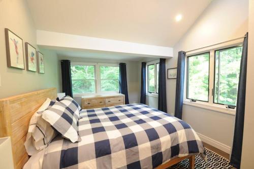ein Schlafzimmer mit einem Bett und zwei Fenstern in der Unterkunft SKI Bike, Hike & Golf Townhouse w/ Hot tub in Ellicottville