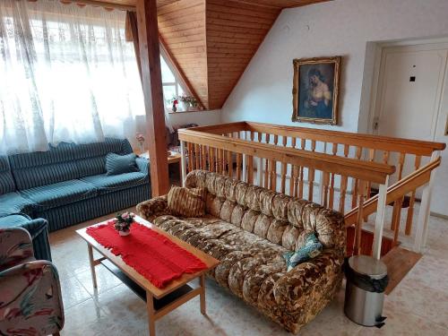ein Wohnzimmer mit einem Sofa und einem Tisch in der Unterkunft Holiday House Retro in Szántód
