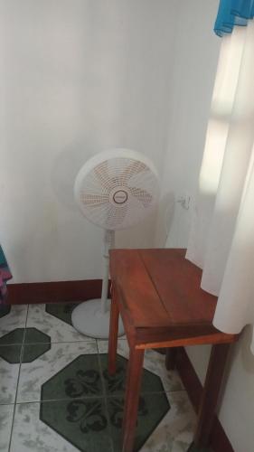 un ventilatore bianco seduto su un piano accanto a un tavolo di Hostel Caballo Blanco a Moyogalpa