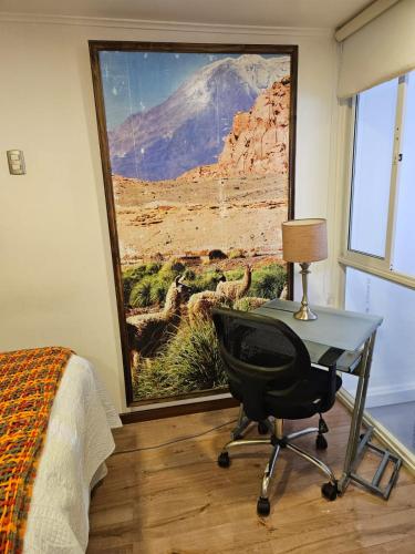 a bedroom with a desk and a picture of a mountain at Hotel Boutique Terra Diaguita & Spa in La Serena