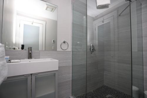 uma casa de banho com uma cabina de duche em vidro e um lavatório. em Charming & Stylish Studio on Beacon Hill #2 em Boston