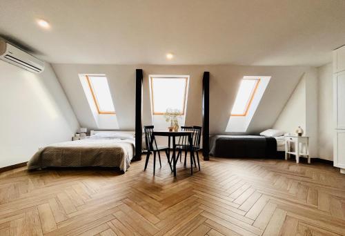 um quarto com 2 camas, uma mesa e 2 janelas em Apartamenty Kamienica Centrum em Lubin