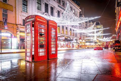 dos cabinas de teléfonos rojos en una calle de la ciudad por la noche en Chic studio in Leicester Sqaure! en Londres