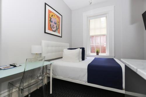 a bedroom with a bed and a desk and a window at Charming & Stylish Studio on Beacon Hill #2 in Boston